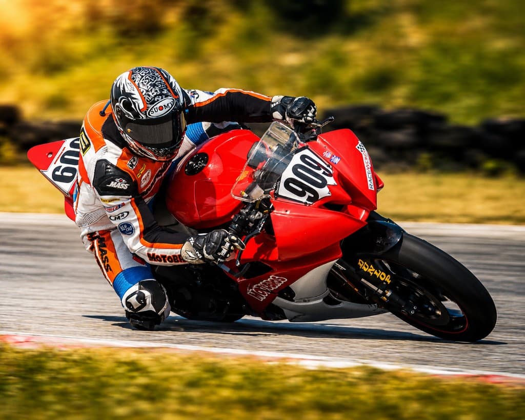 MotoBros rider on a red sportbike pushing limits on track